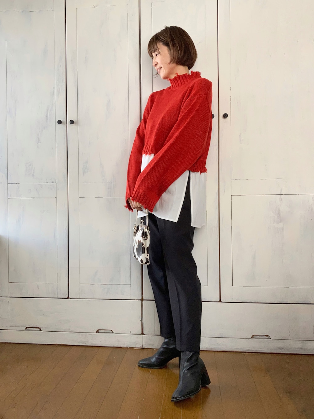 ブルー系のノーカラーコート、レッド系のニット/セーター、ブラック系のスーツセットを着用したレディースの秋コーディネートの2枚目の写真