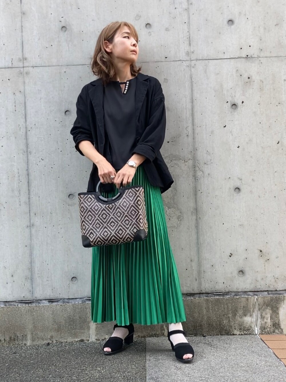 グリーン系のスカート、ブラック系のシャツ/ブラウス、ブラック系のテーラードジャケットを着用したレディースの夏コーディネートの3枚目の写真