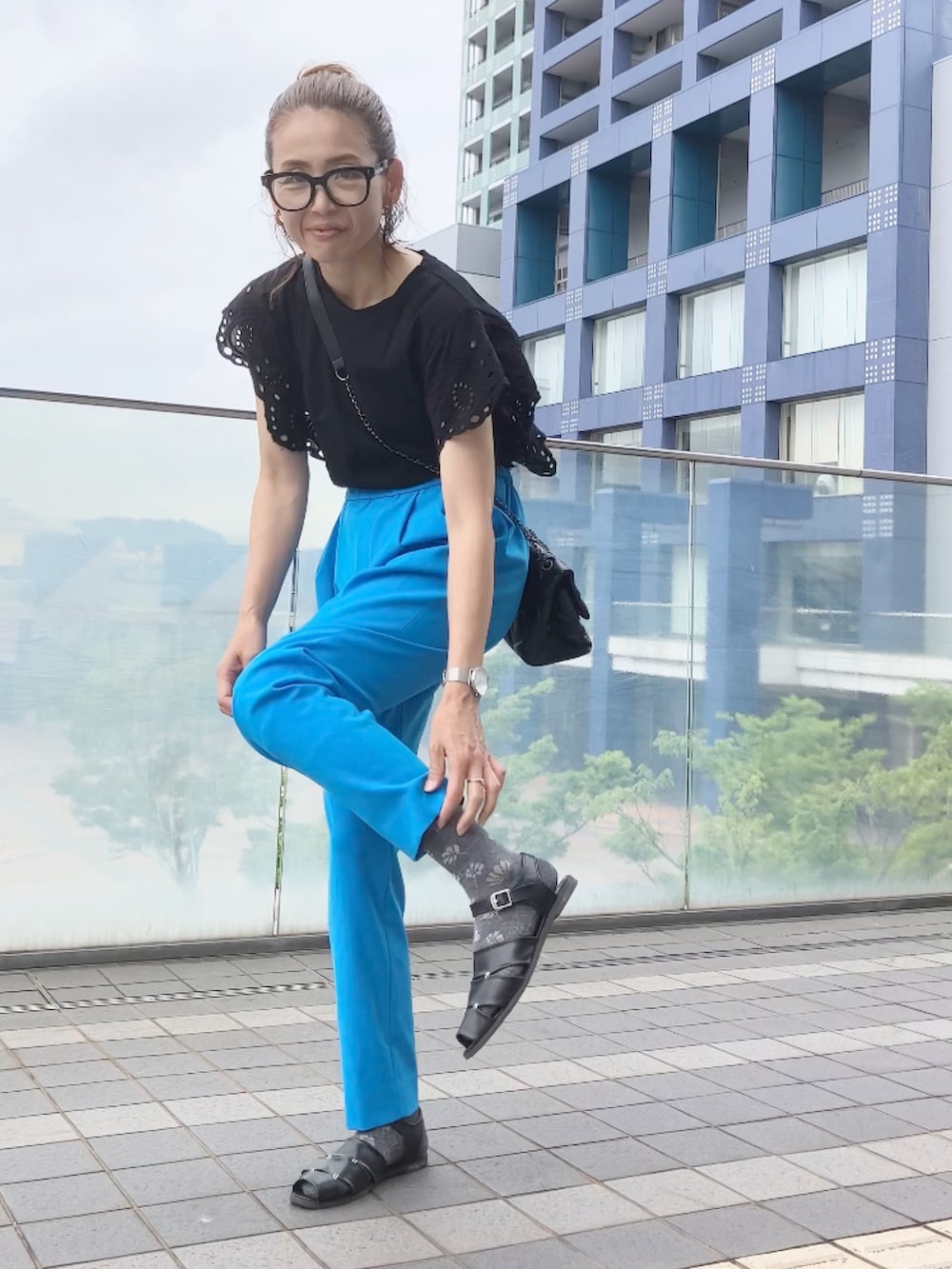 ブルー系のその他パンツ、ブラック系のTシャツ/カットソー、ブラック系のショルダーバッグを着用したレディースの夏コーディネートの4枚目の写真