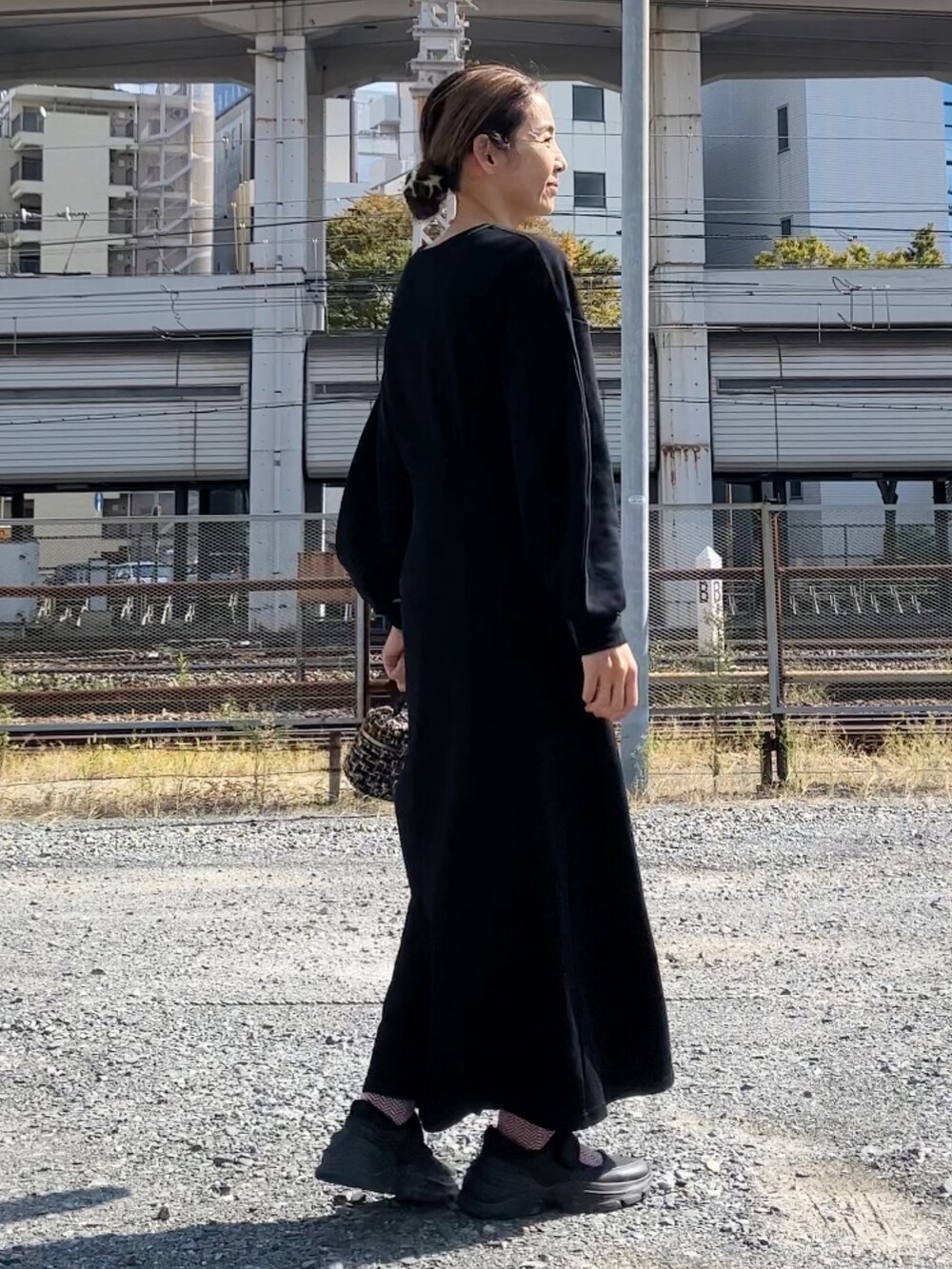ブラック系のワンピース、その他のハンドバッグ、ブラック系のシューズを着用したレディースの秋コーディネートの4枚目の写真