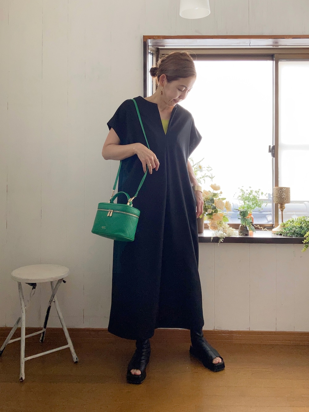 ブラック系のワンピース、グリーン系のタンクトップ、グリーン系のショルダーバッグを着用したレディースの夏コーディネートの2枚目の写真