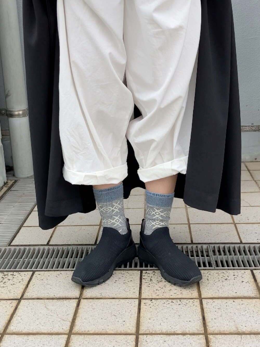 ブラック系のワンピース、ホワイト系のチノパンツ、ブラック系のシューズを着用したレディースの夏コーディネートの4枚目の写真