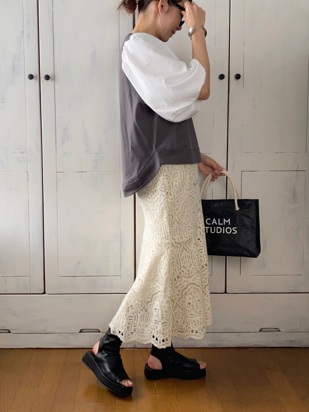 ブラック系のその他トップス、ホワイト系のスカート、ブラック系のブーツを着用したレディースの春コーディネートの3枚目の写真