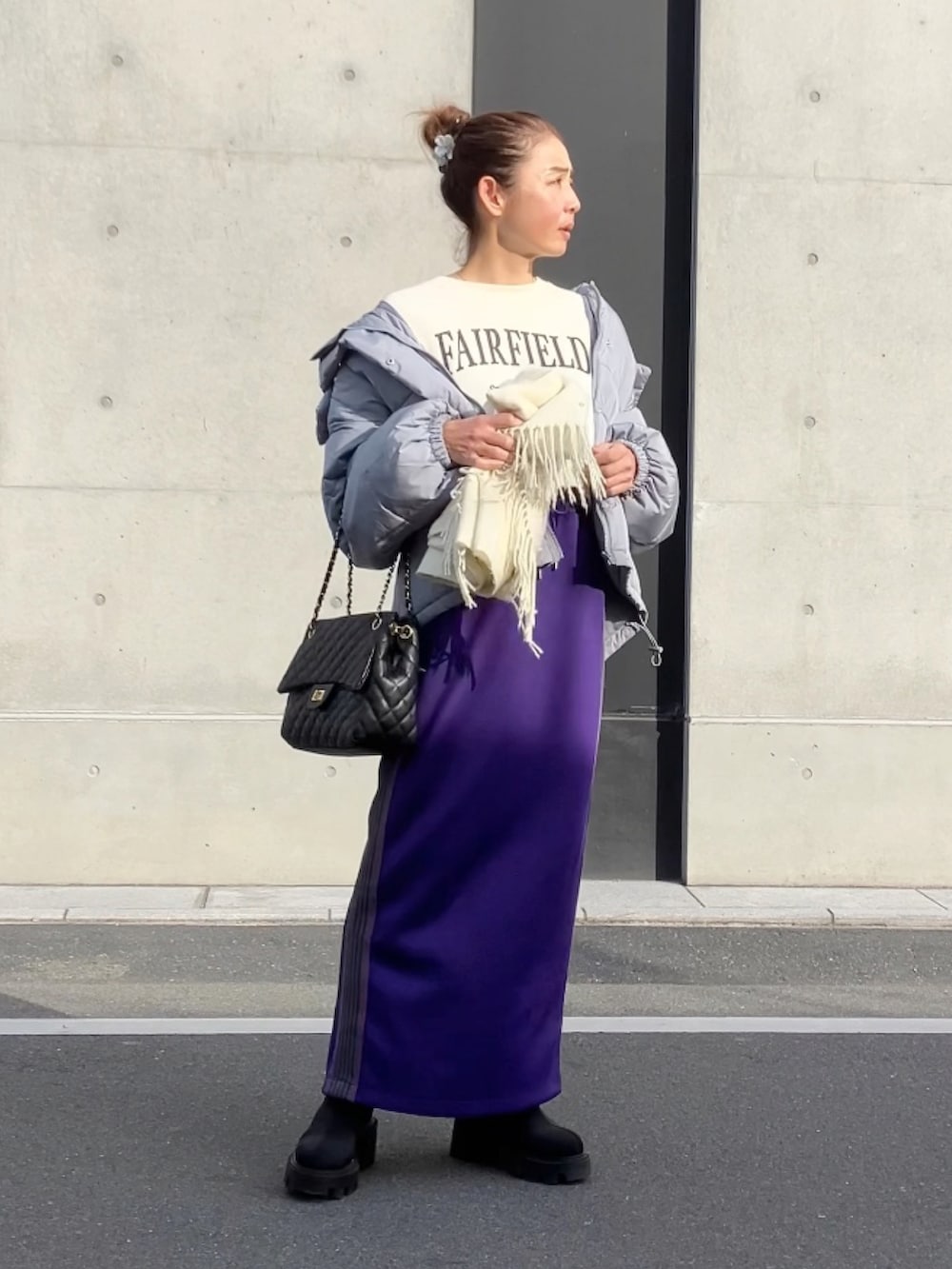 パープル系のスカート、ホワイト系のスウェット、グレー系のダウンジャケット/コートを着用したレディースの冬コーディネートの5枚目の写真