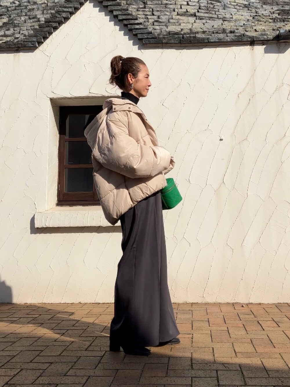 ホワイト系のダウンジャケット/コート、ブラック系のニット/セーター、グレー系のその他パンツを着用したレディースの冬コーディネートの4枚目の写真