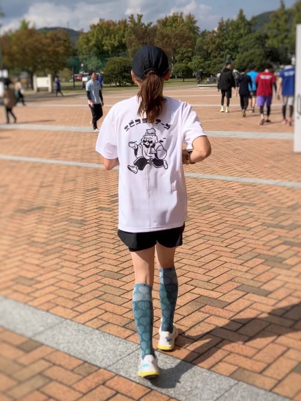 ブラック系のジャージ、オレンジ系のショルダーバッグ、ブラック系のレギンス/スパッツを着用したレディースの秋コーディネートの4枚目の写真