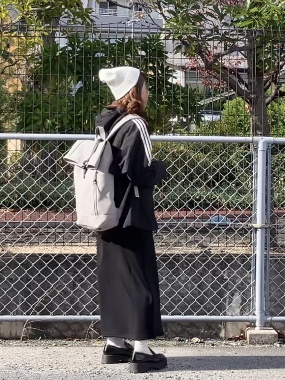 ブラック系のブルゾン、ブラック系のジャンパースカート、ブラック系のローファーを着用したレディースの冬コーディネートの2枚目の写真