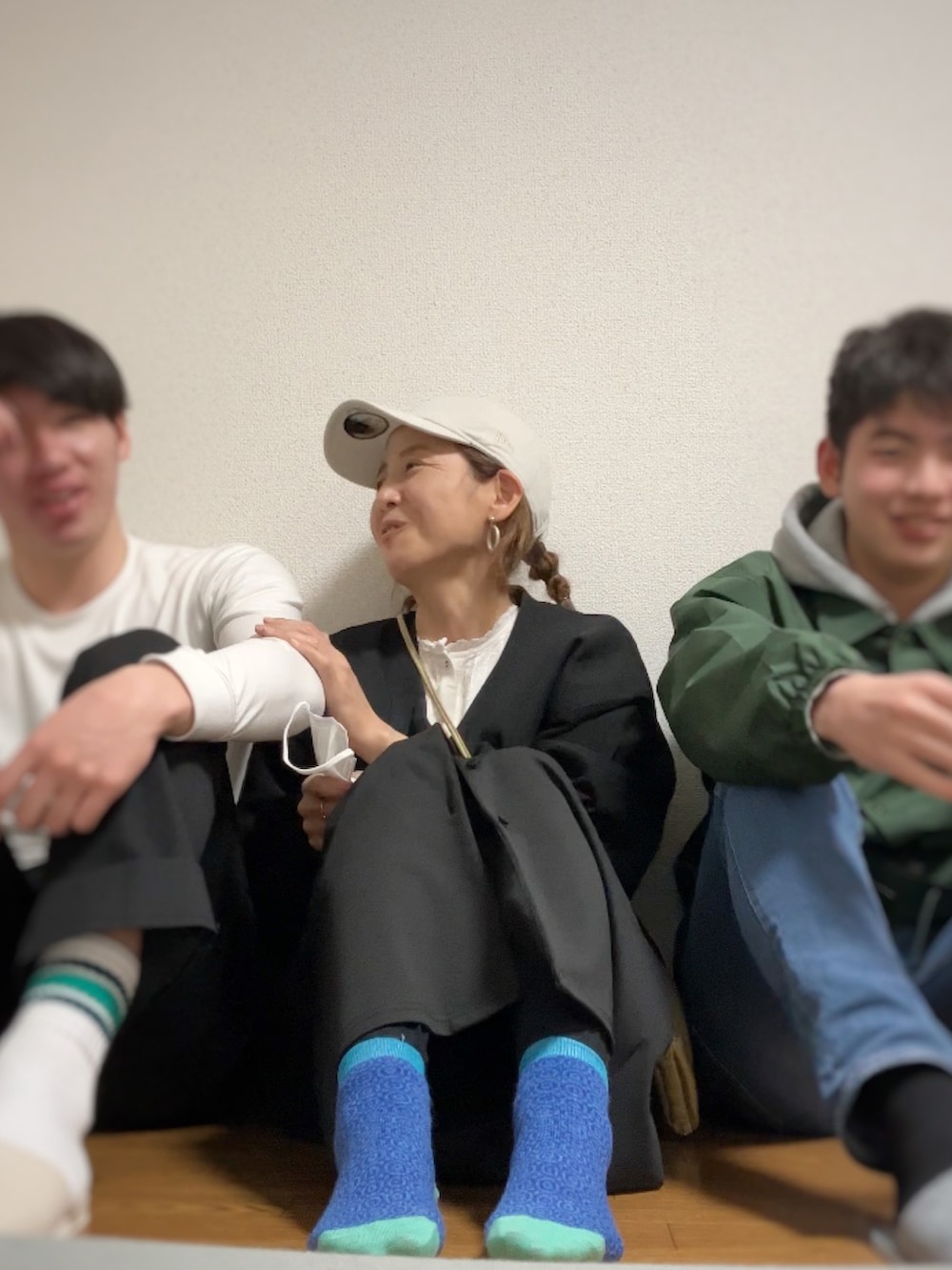 ブラック系のモッズコート、ブラック系のカーディガン/ボレロ、ホワイト系のシャツ/ブラウスを着用したレディースの春コーディネートの2枚目の写真