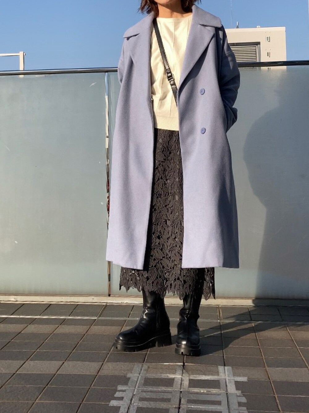 ホワイト系のニット/セーター、ブルー系のチェスターコート、ブラウン系のショルダーバッグを着用したレディースの秋コーディネートの5枚目の写真