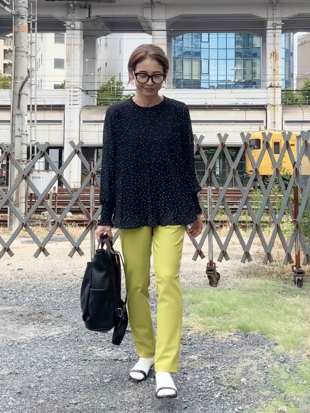 グリーン系のパンツ、ブラック系のシャツ/ブラウス、ブラック系のバックパック/リュックを着用したレディースの秋コーディネートの4枚目の写真