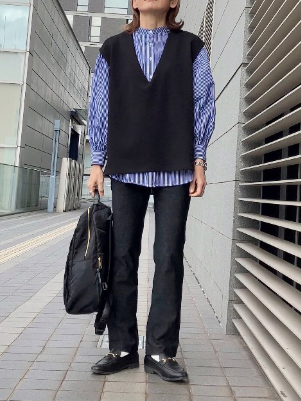 ブラック系のパンツ、ブラック系のベスト、ブラック系のバックパック/リュックを着用したレディースの冬コーディネートの2枚目の写真