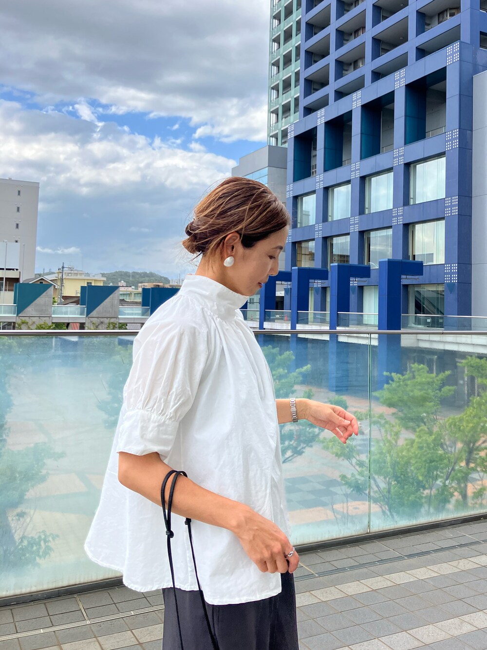 ホワイト系のシャツ/ブラウス、ブラック系のバッグ、ブラック系のシューズを着用したレディースの夏コーディネートの2枚目の写真