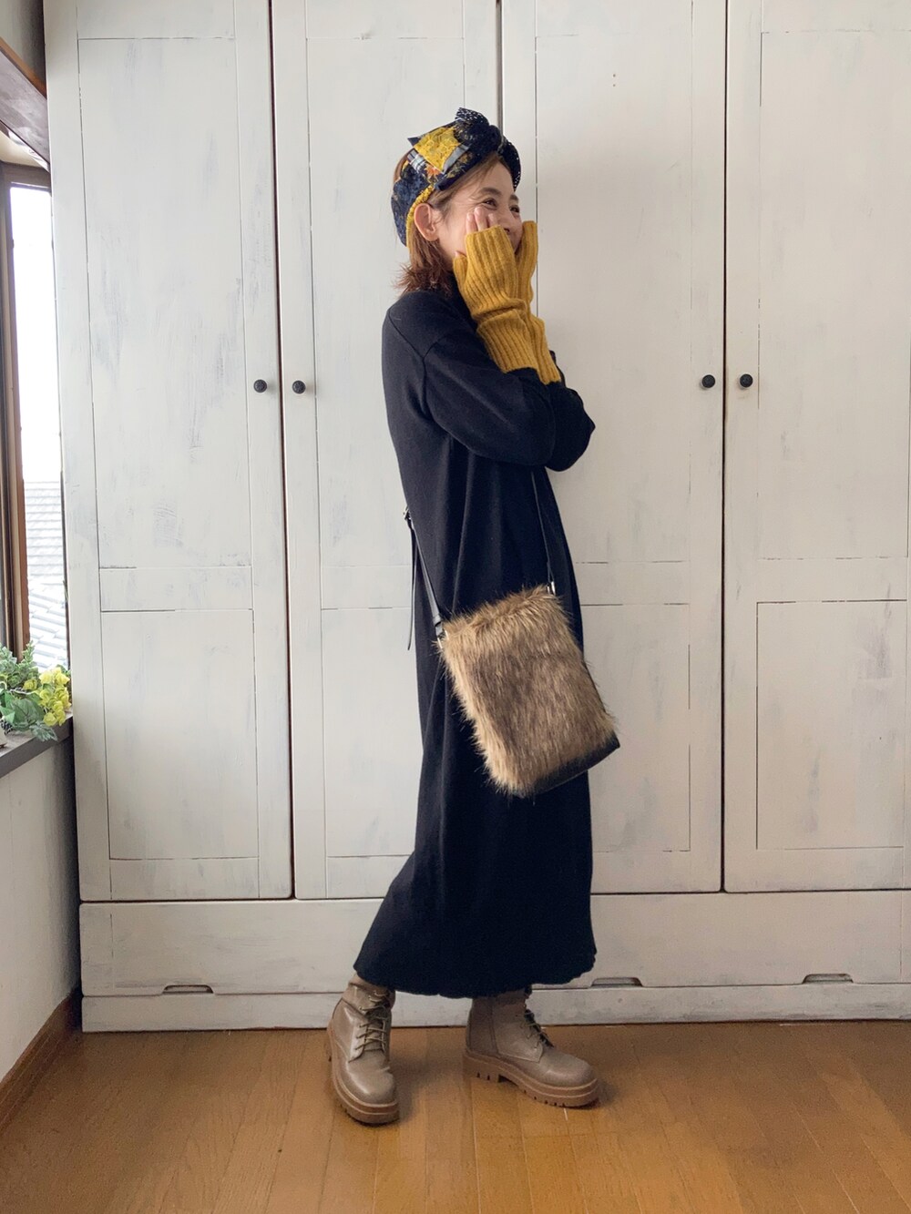 ブラック系のワンピース、ブラウン系のショルダーバッグ、ブラウン系のブーツを着用したレディースの秋コーディネートの3枚目の写真