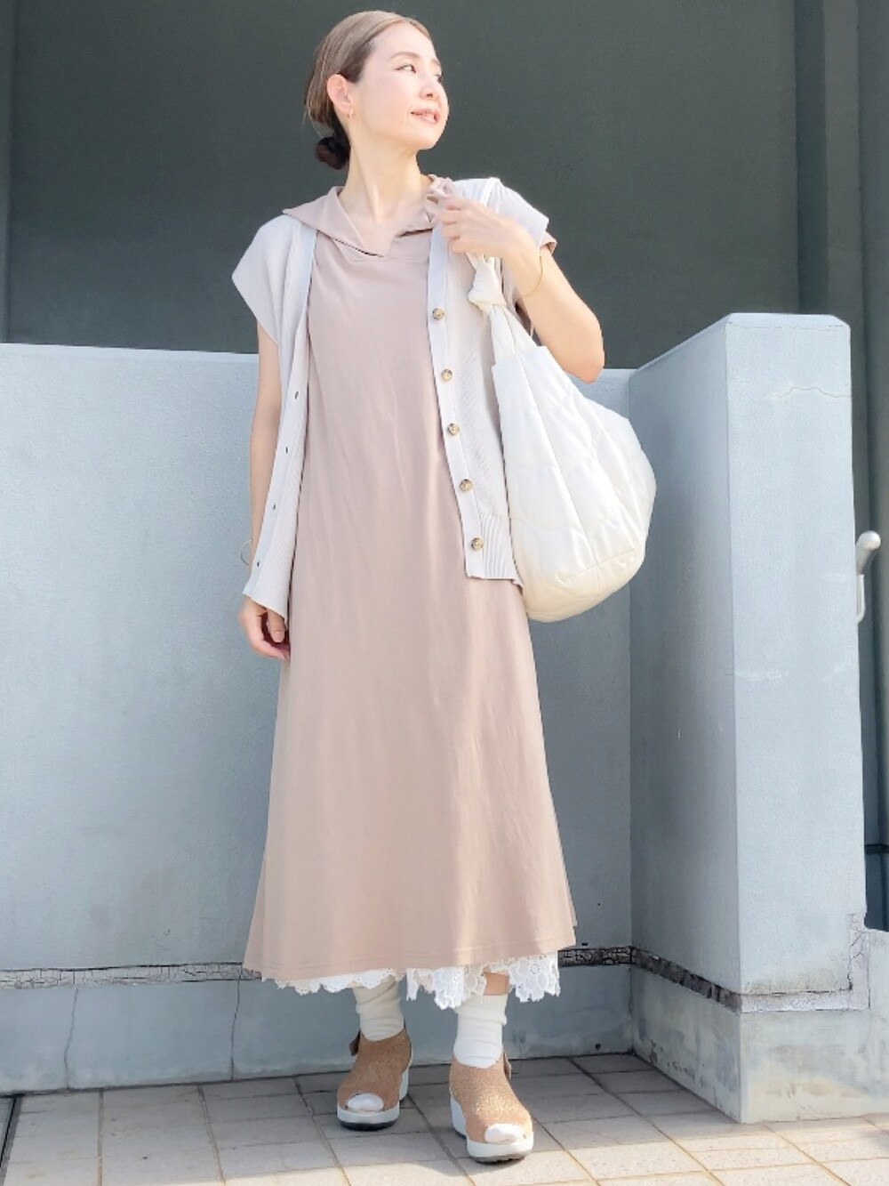 ベージュ系のベスト、ベージュ系のワンピース、ホワイト系のショルダーバッグを着用したレディースの夏コーディネートの4枚目の写真