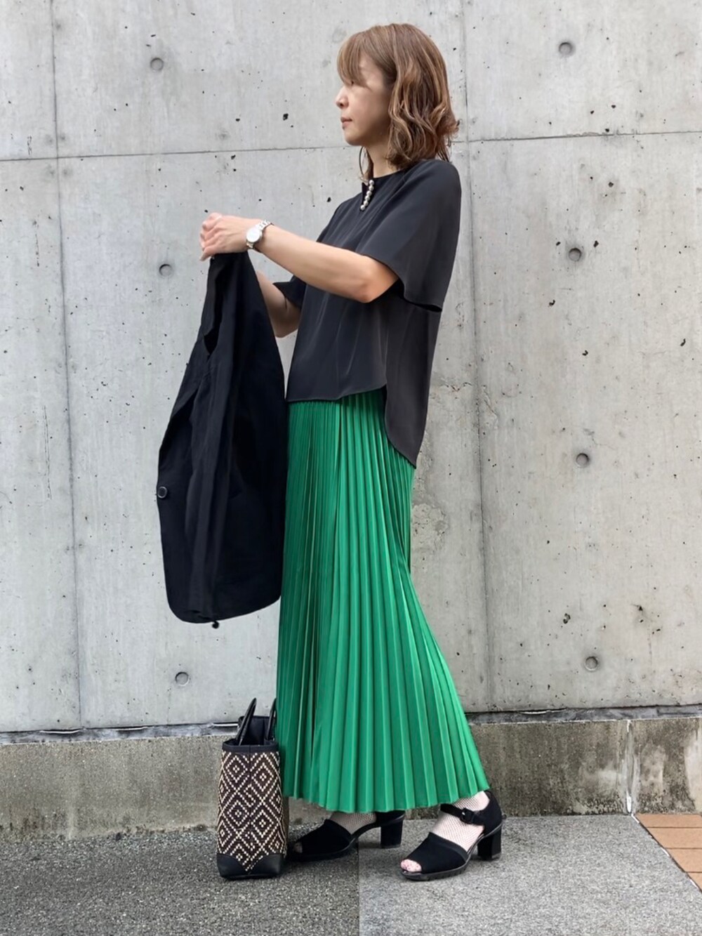 グリーン系のスカート、ブラック系のシャツ/ブラウス、ブラック系のテーラードジャケットを着用したレディースの夏コーディネートの4枚目の写真