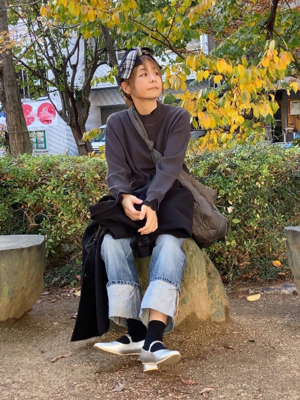 ブラック系のステンカラーコート、グレー系のニット/セーター、グレー系のショルダーバッグを着用したレディースの秋コーディネートの3枚目の写真