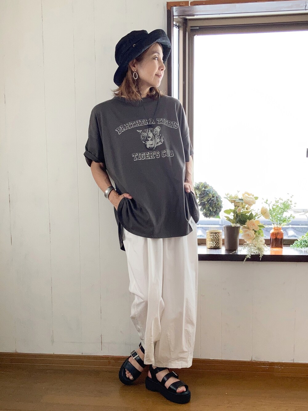 グレー系のTシャツ/カットソー、ホワイト系のチノパンツ、ブラック系のサンダルを着用したレディースの夏コーディネートの2枚目の写真