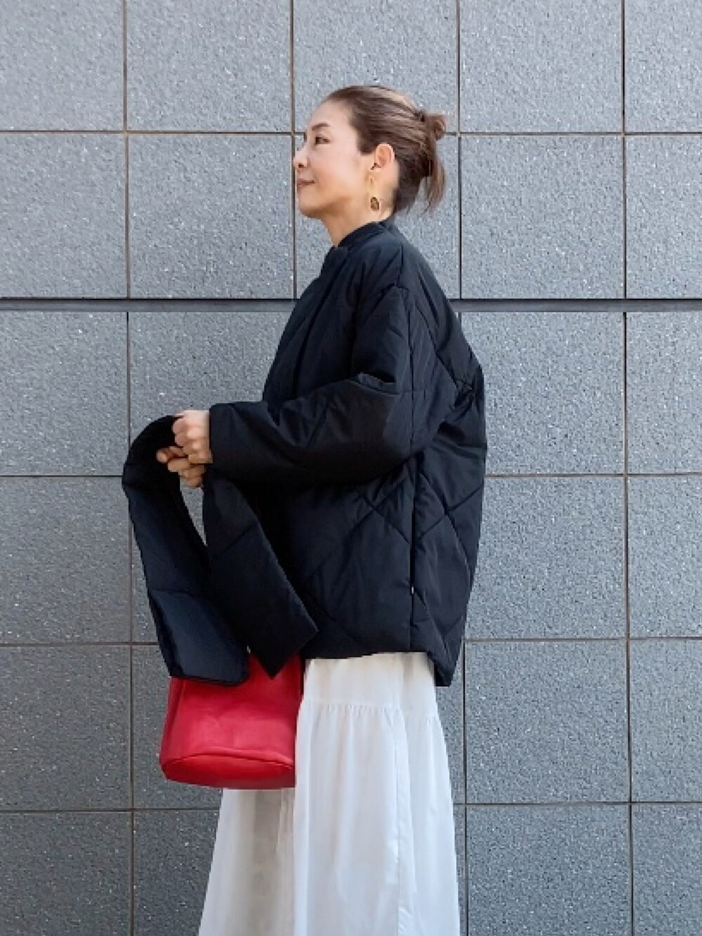 ブラック系のダウンジャケット/コート、ベージュ系のベスト、ホワイト系のワンピース/ドレスを着用したレディースの秋コーディネートの3枚目の写真