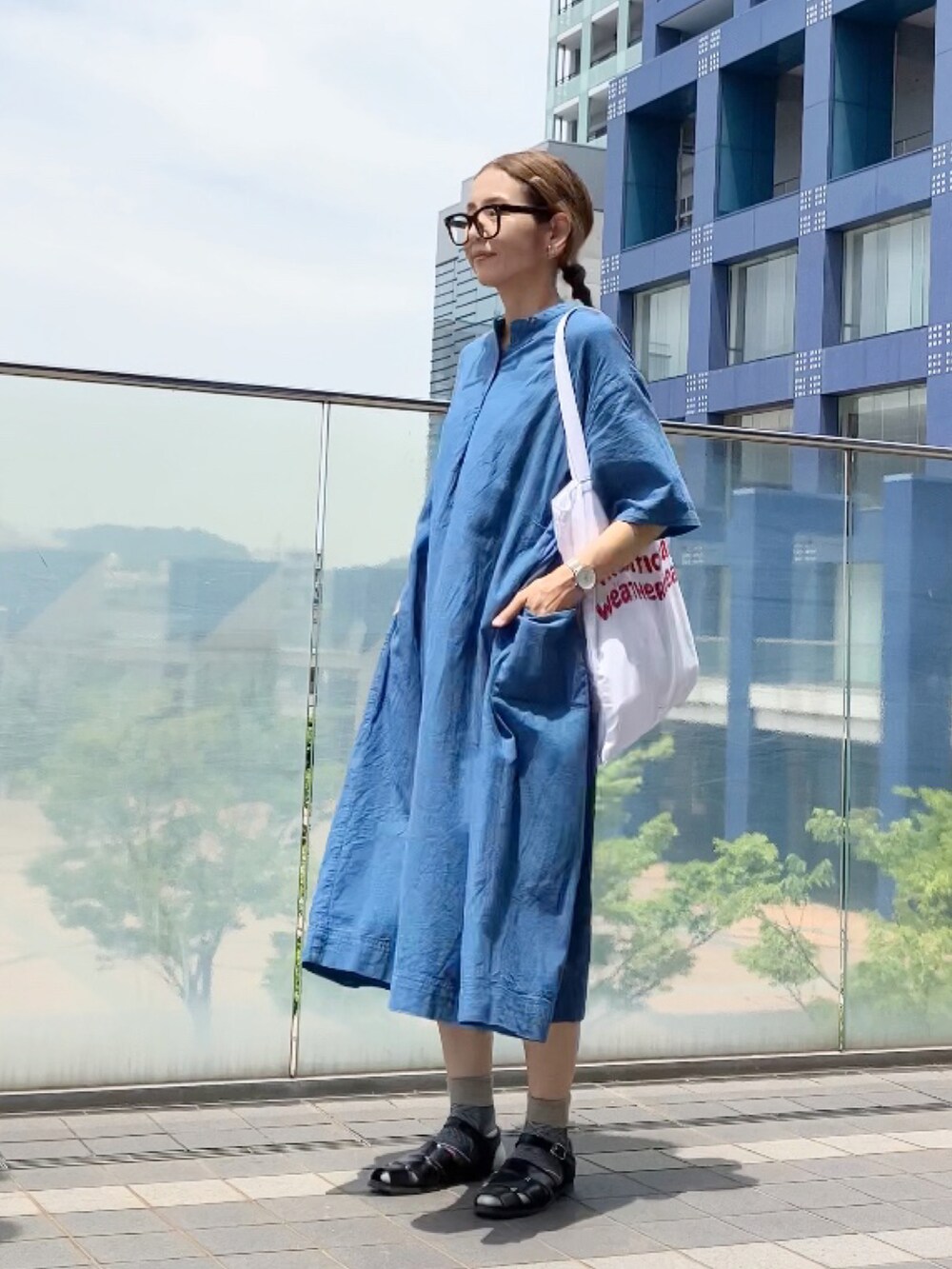 ブルー系のワンピース/ドレス、ブラック系のサンダル、レッド系のトートバッグを着用したレディースの夏コーディネートの3枚目の写真