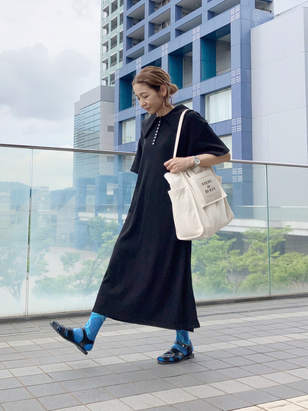 ブラック系のワンピース、ホワイト系のトートバッグ、ブラック系のサンダルを着用したレディースの夏コーディネートの2枚目の写真