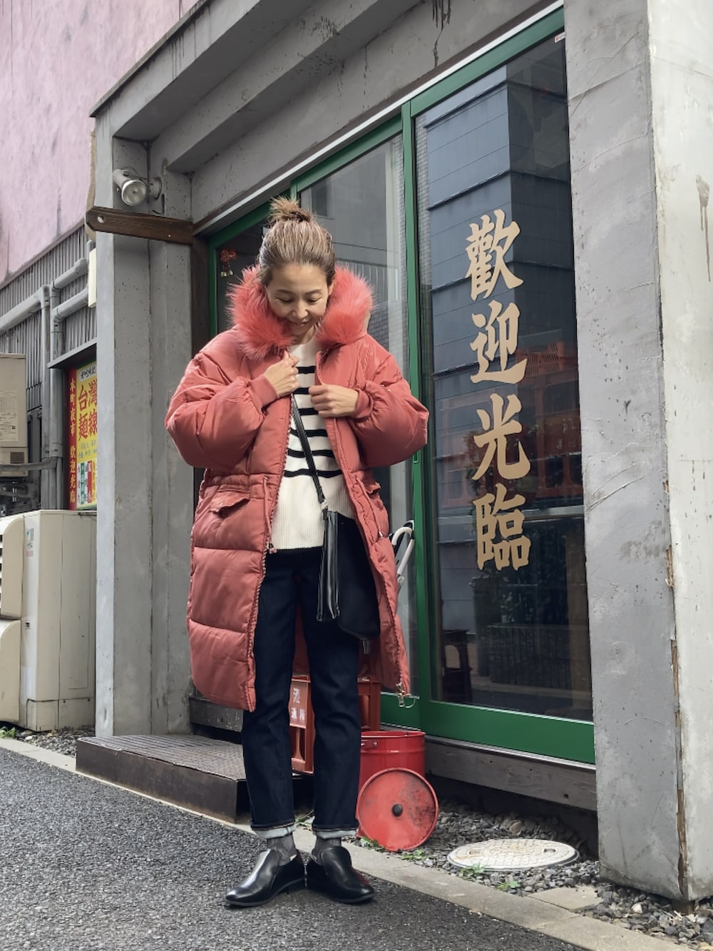 レッド系のダウンジャケット/コート、ブルー系のデニムパンツ、ブラック系のローファーを着用したレディースの冬コーディネートの2枚目の写真