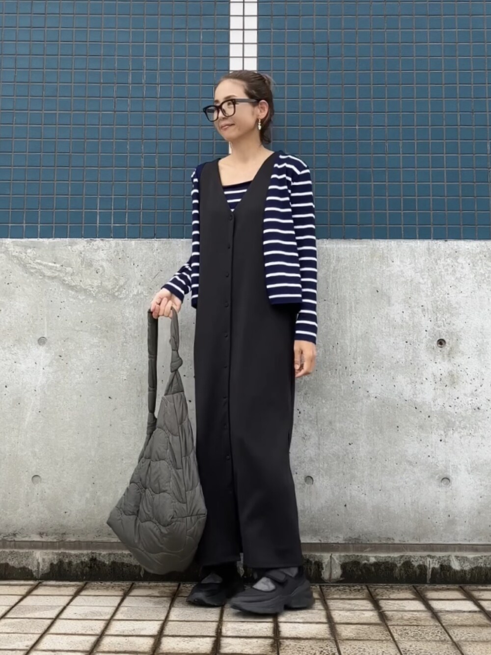 ブラック系のジャンパースカート、ブルー系のアンサンブル、ブラック系のシューズを着用したレディースの夏コーディネートの4枚目の写真