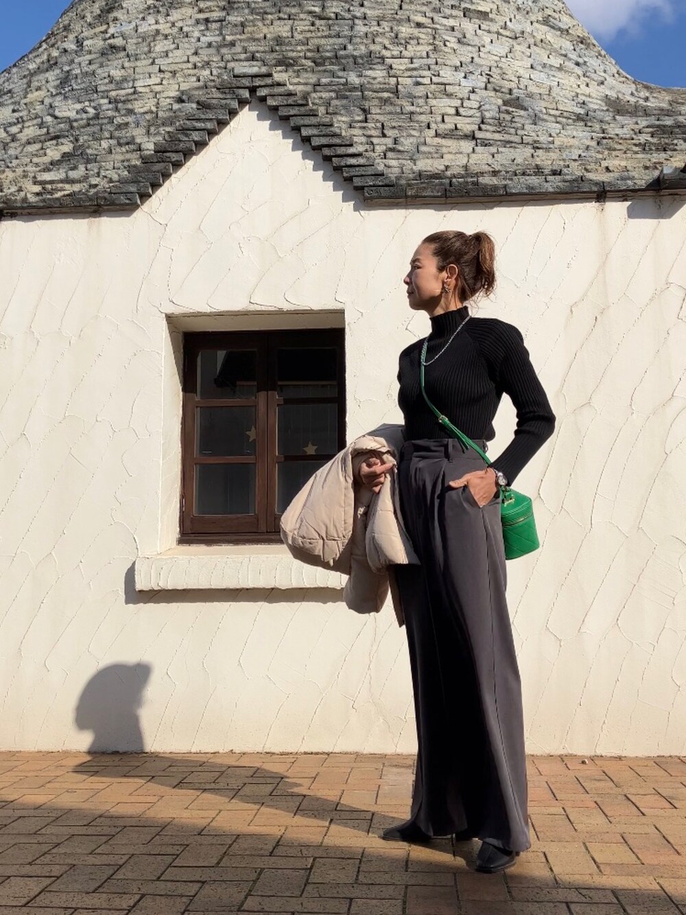 ホワイト系のダウンジャケット/コート、ブラック系のニット/セーター、グレー系のその他パンツを着用したレディースの冬コーディネートの2枚目の写真