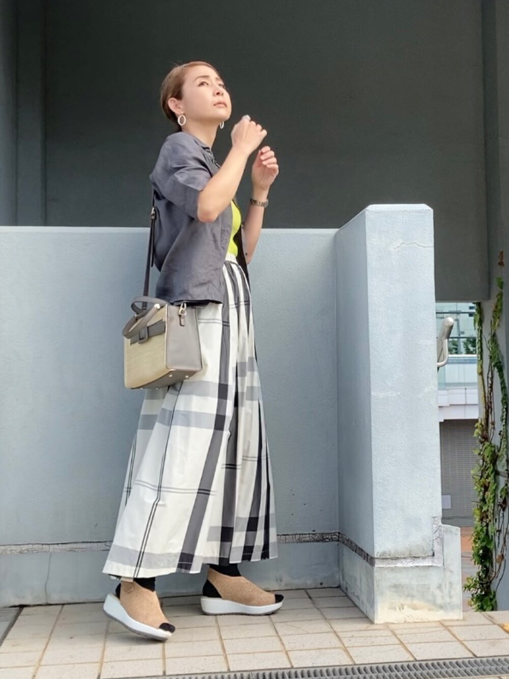 グレー系のシャツ/ブラウス、ホワイト系のスカート、グリーン系のタンクトップを着用したレディースの夏コーディネートの5枚目の写真