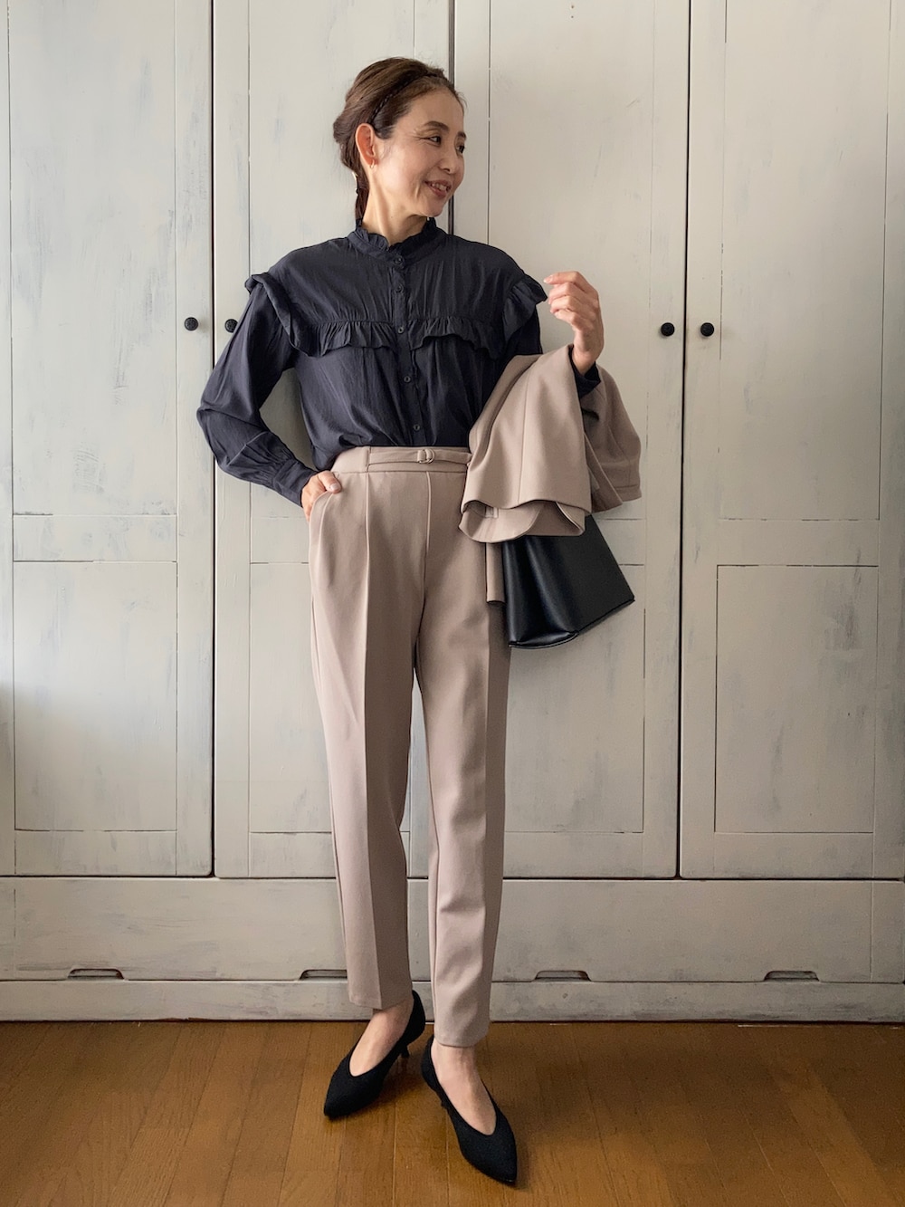 ベージュ系のスーツセット、ブラック系のシャツ/ブラウス、ブラック系のハンドバッグを着用したレディースの春コーディネートの2枚目の写真