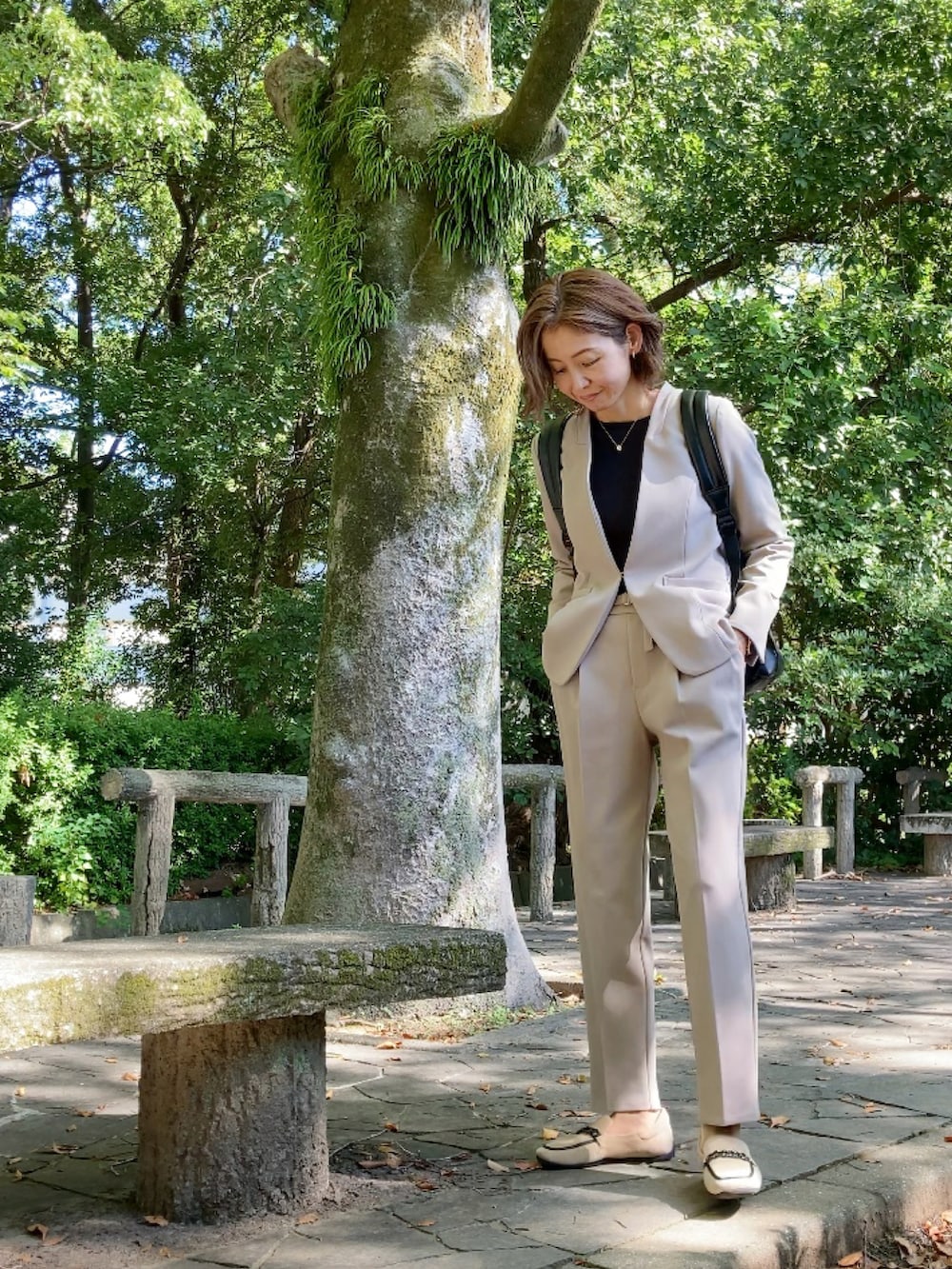 ベージュ系のスーツセット、ベージュ系のシューズ、ブラウン系のバックパック/リュックを着用したレディースの秋コーディネートの3枚目の写真