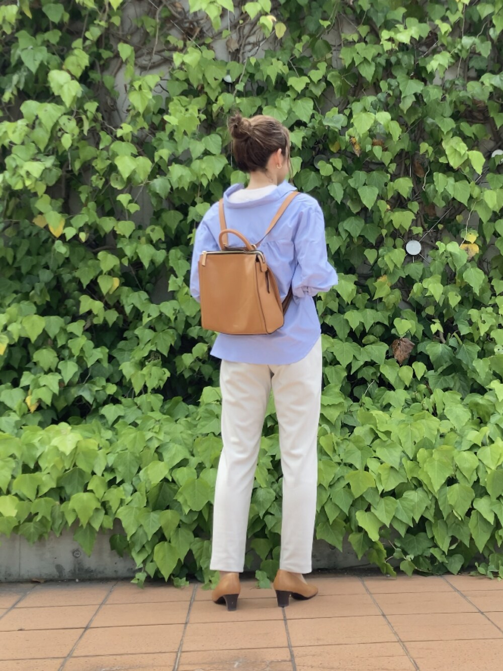 イエロー系のバックパック/リュック、ホワイト系のパンツ、ブルー系のその他トップスを着用したレディースの秋コーディネートの4枚目の写真