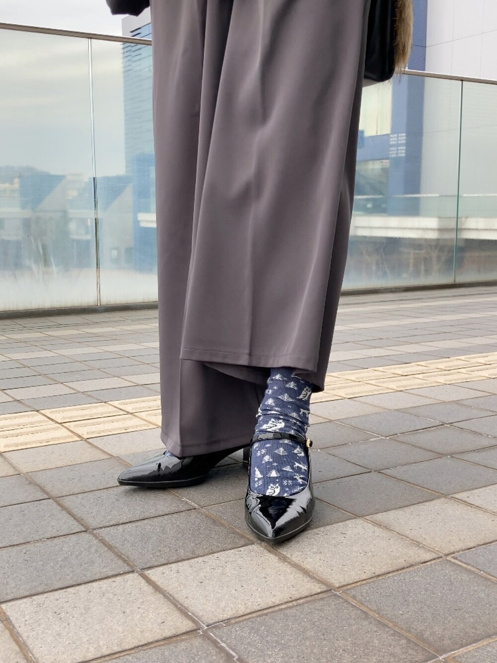 ブラック系のダウンジャケット/コート、ホワイト系のTシャツ/カットソー、グレー系のその他パンツを着用したレディースの冬コーディネートの2枚目の写真