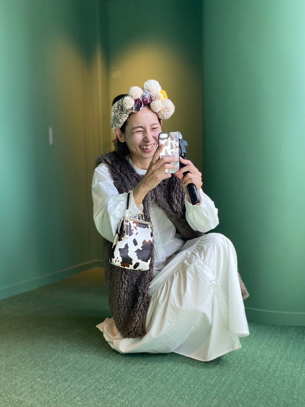 グレー系のベスト、イエロー系のブーツ、ベージュ系のヘアバンドを着用したレディースの秋コーディネートの3枚目の写真