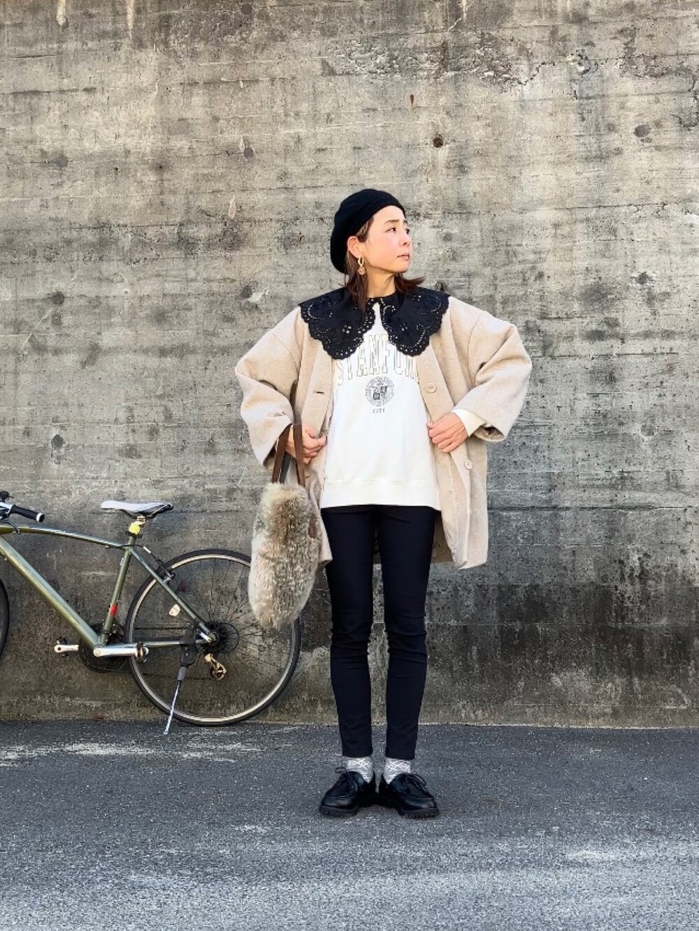 ブラック系のモカシン/デッキシューズ、ホワイト系のスウェット、ベージュ系のノーカラーコートを着用したレディースの冬コーディネートの5枚目の写真