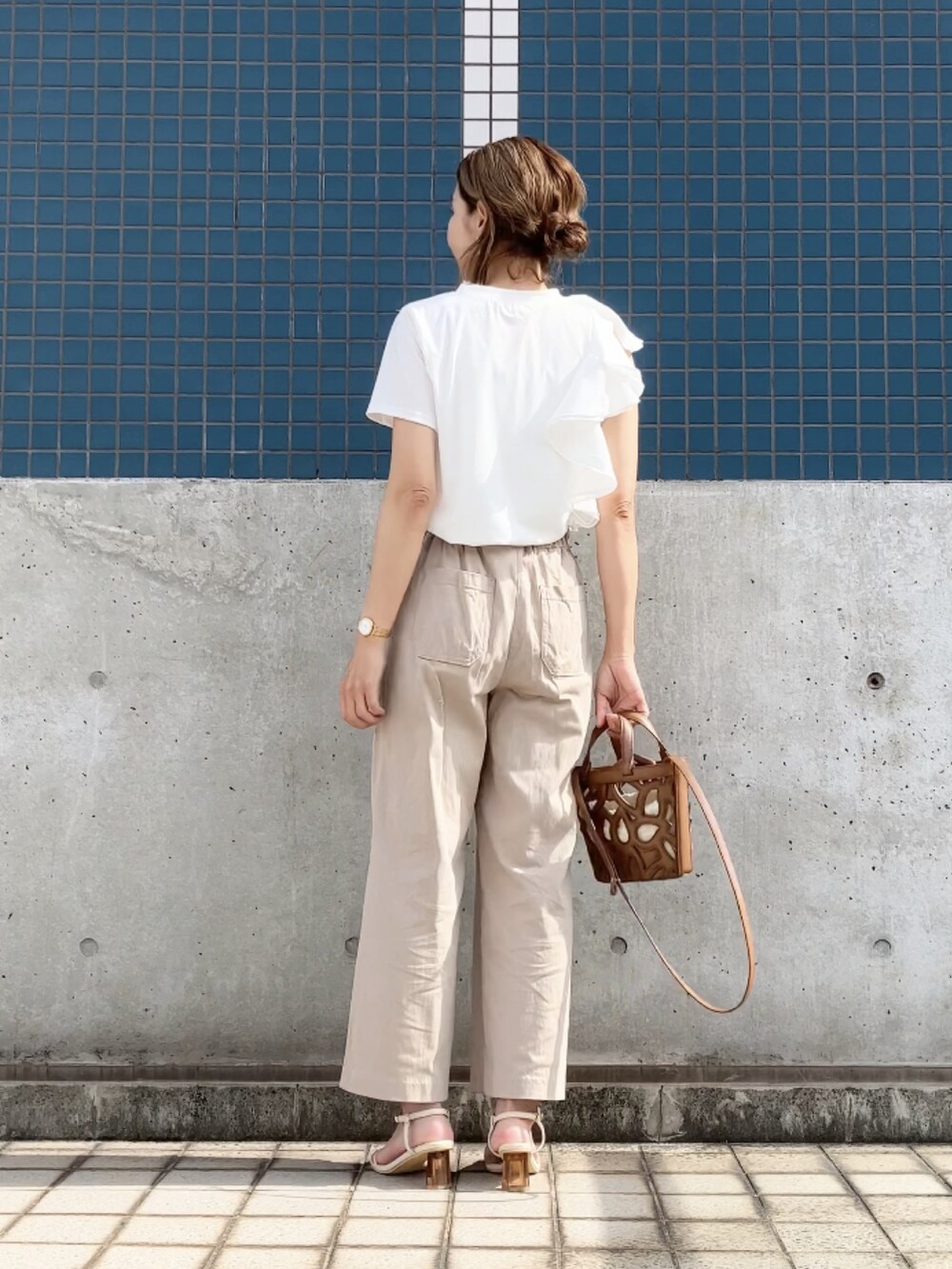 ホワイト系のTシャツ/カットソー、ベージュ系のパンツ、ブラウン系のバッグを着用したレディースの夏コーディネートの2枚目の写真