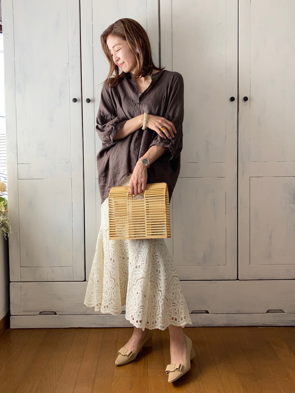 ブラウン系のトップス、ホワイト系のスカート、ベージュ系のパンプスを着用したレディースの夏コーディネートの2枚目の写真