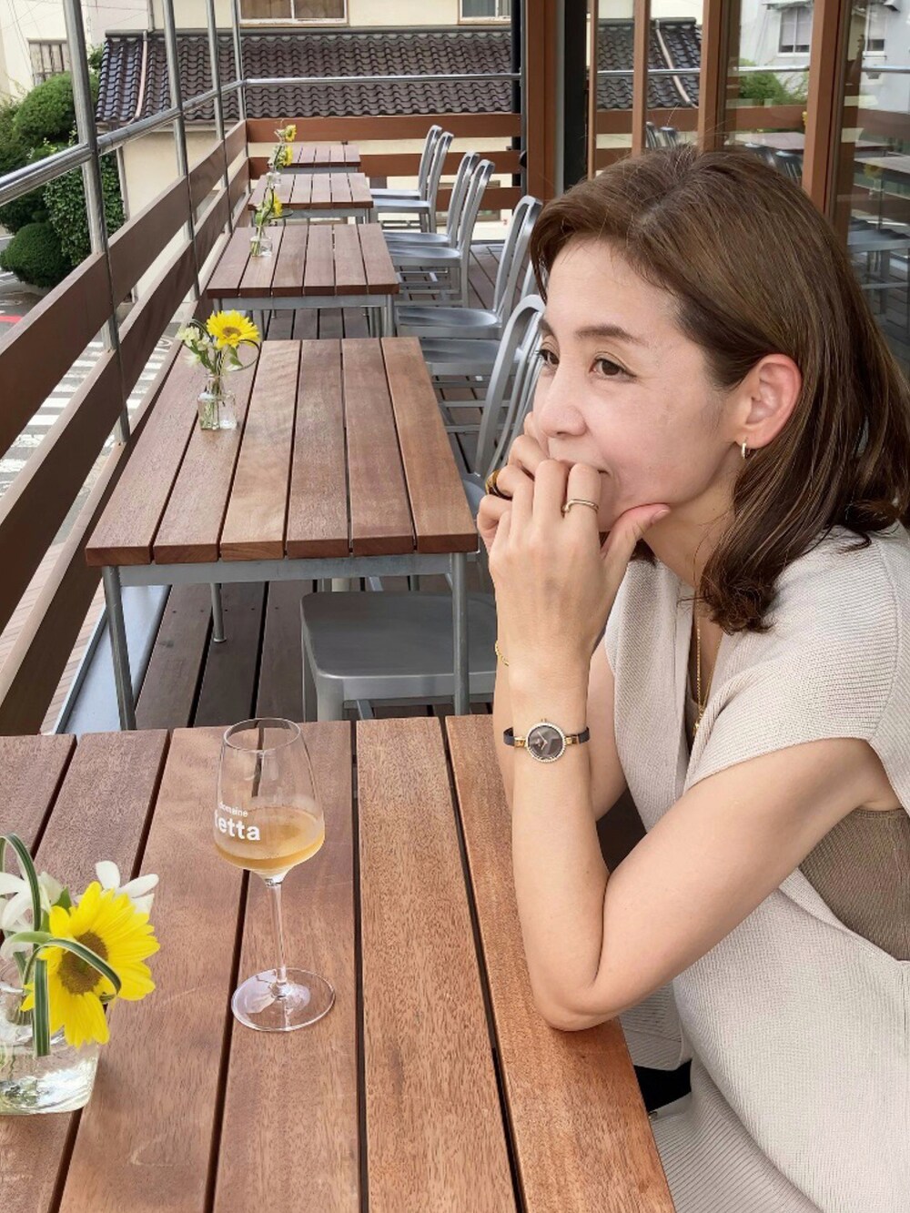 ベージュ系のベスト、ブラック系のパンツ、ブラウン系のかごバッグを着用したレディースの夏コーディネートの3枚目の写真