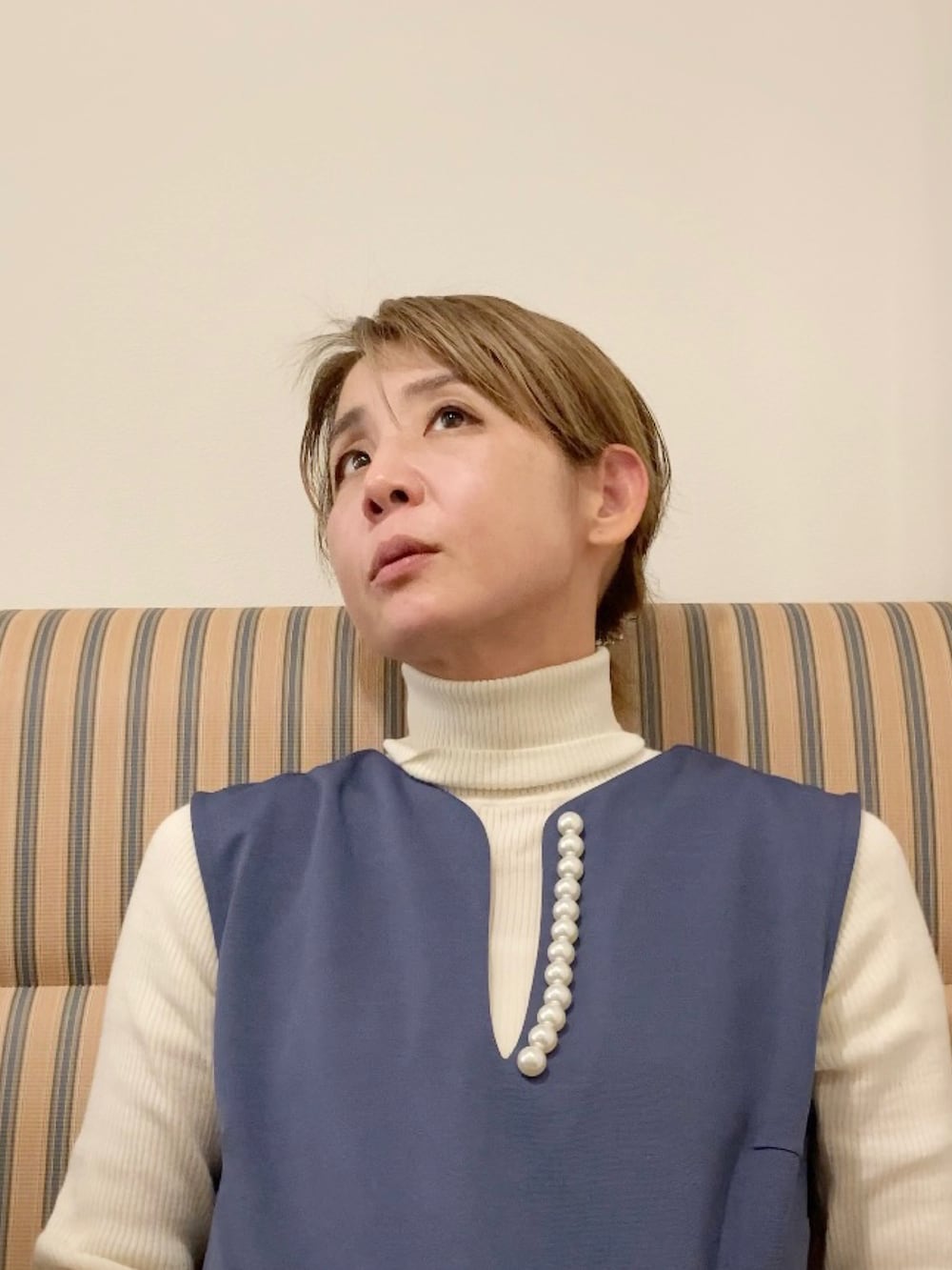 ブラック系のダウンジャケット/コート、ブルー系のワンピース、ブラック系のハンドバッグを着用したレディースの冬コーディネートの3枚目の写真