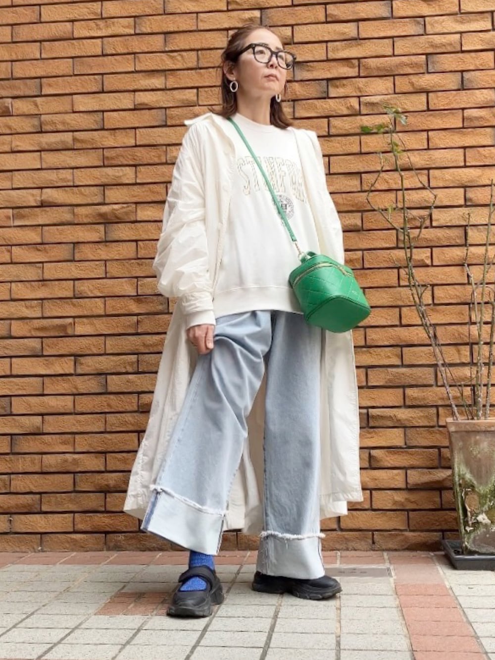 ホワイト系のスウェット、ブルー系のデニムパンツ、グリーン系のショルダーバッグを着用したレディースの春コーディネートの5枚目の写真