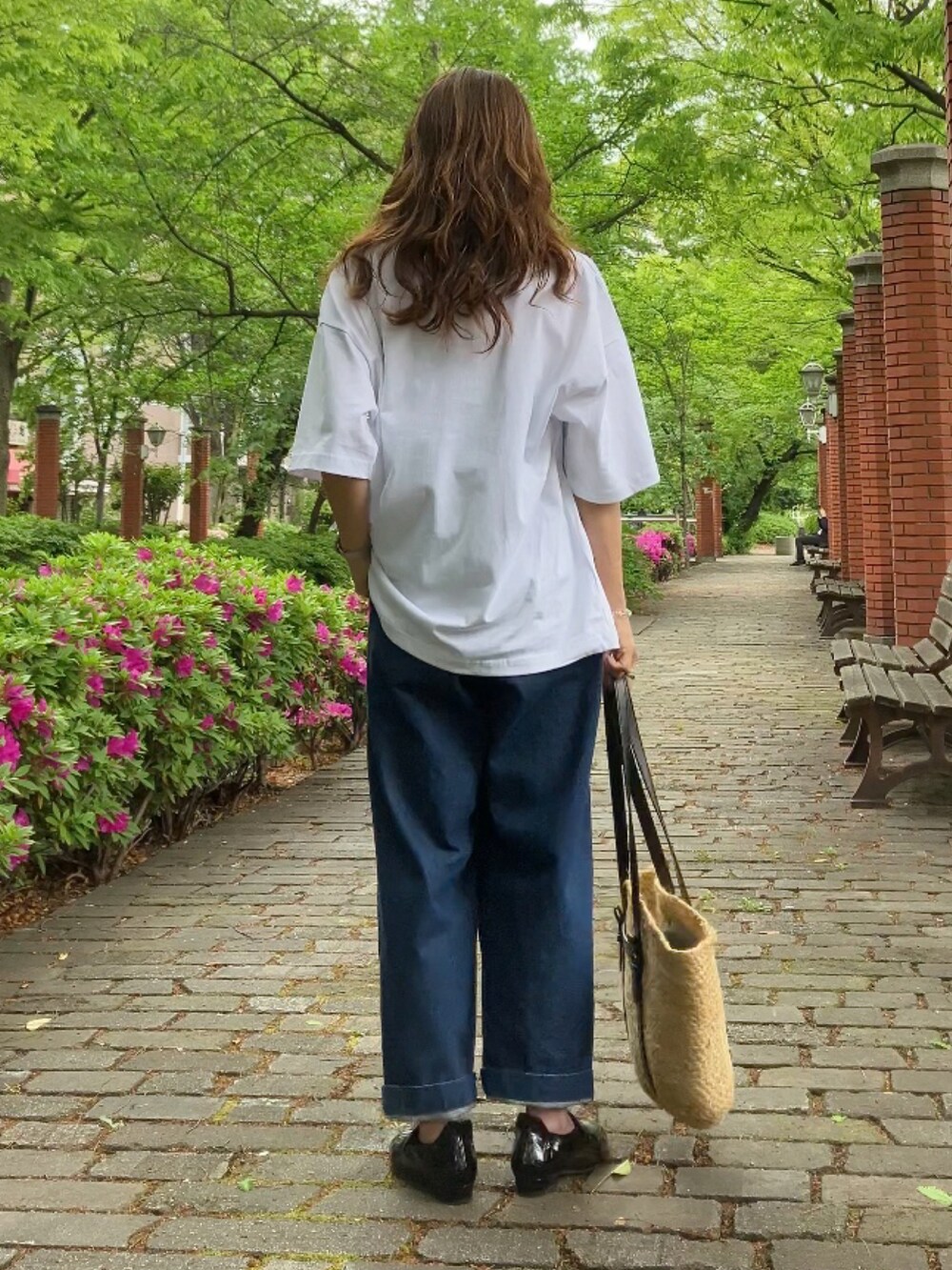 ホワイト系のTシャツ/カットソー、ブルー系のデニムパンツ、ブラック系のシューズを着用したレディースの春コーディネートの3枚目の写真