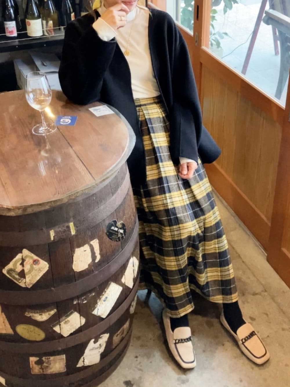 ベージュ系のシューズ、ブラック系のジャケット/アウター、イエロー系のスカートを着用したレディースの秋コーディネートの4枚目の写真