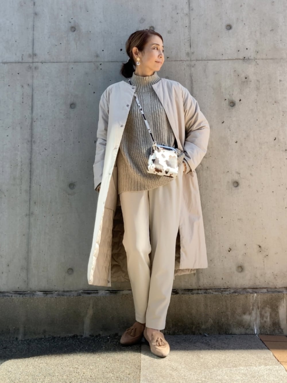 ホワイト系のパンツ、ベージュ系のニット/セーター、ベージュ系のシューズを着用したレディースの秋コーディネートの2枚目の写真