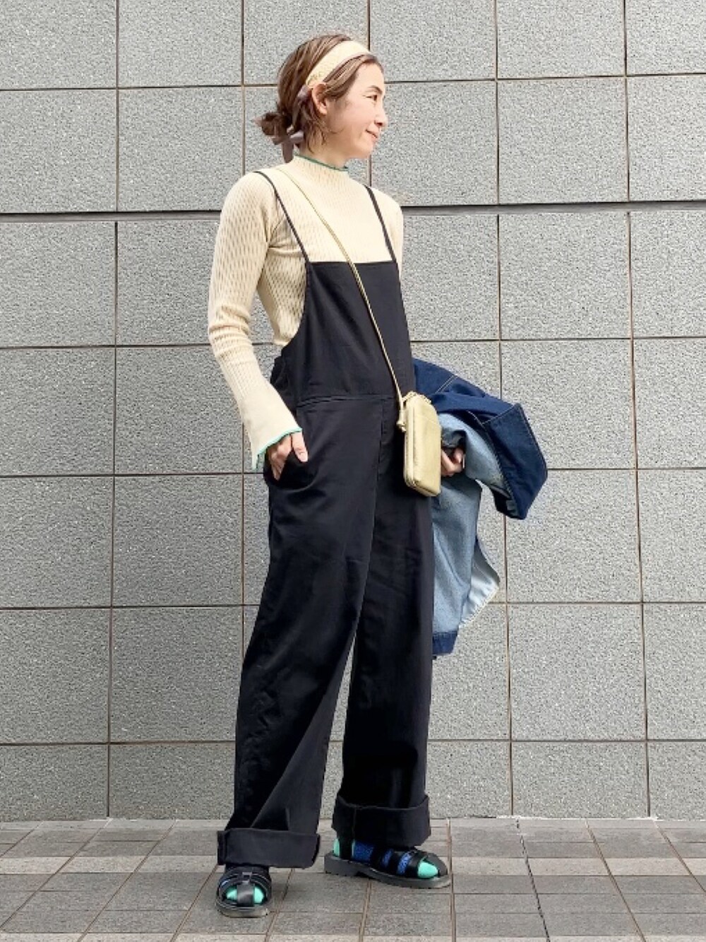 ブラック系のサロペット/オーバーオール、ホワイト系のニット/セーター、ブルー系のデニムジャケットを着用したレディースの春コーディネートの3枚目の写真