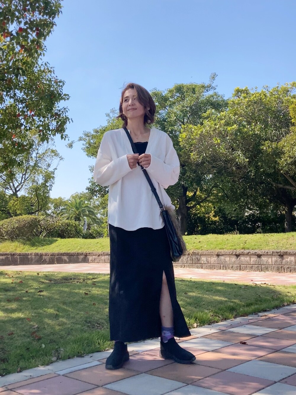 ブラック系のシューズ、ホワイト系のスウェット、ブラウン系のショルダーバッグを着用したレディースの秋コーディネートの3枚目の写真