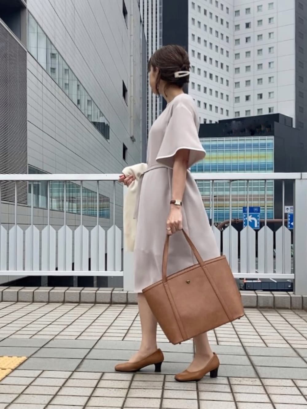 ベージュ系のワンピース、ベージュ系のパンプス、ブラウン系のバッグを着用したレディースの春コーディネートの3枚目の写真