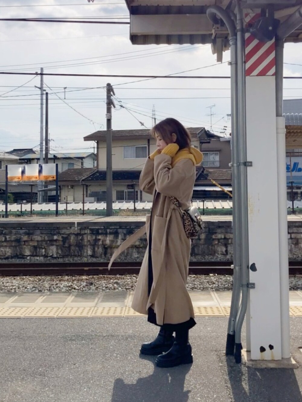 ベージュ系のジャケット/アウター、ブラック系のワンピース、ブラウン系のショルダーバッグを着用したレディースの冬コーディネートの2枚目の写真