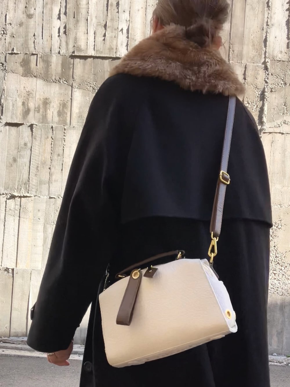 ベージュ系のボストンバッグ、ホワイト系のスニーカー、イエロー系のスカートを着用したレディースの冬コーディネートの2枚目の写真