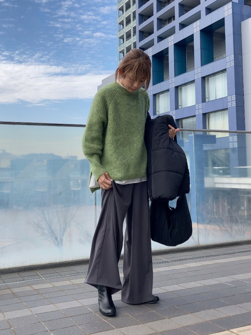 ブラック系のダウンジャケット/コート、グリーン系のニット/セーター、グレー系のその他パンツを着用したレディースの冬コーディネートの3枚目の写真