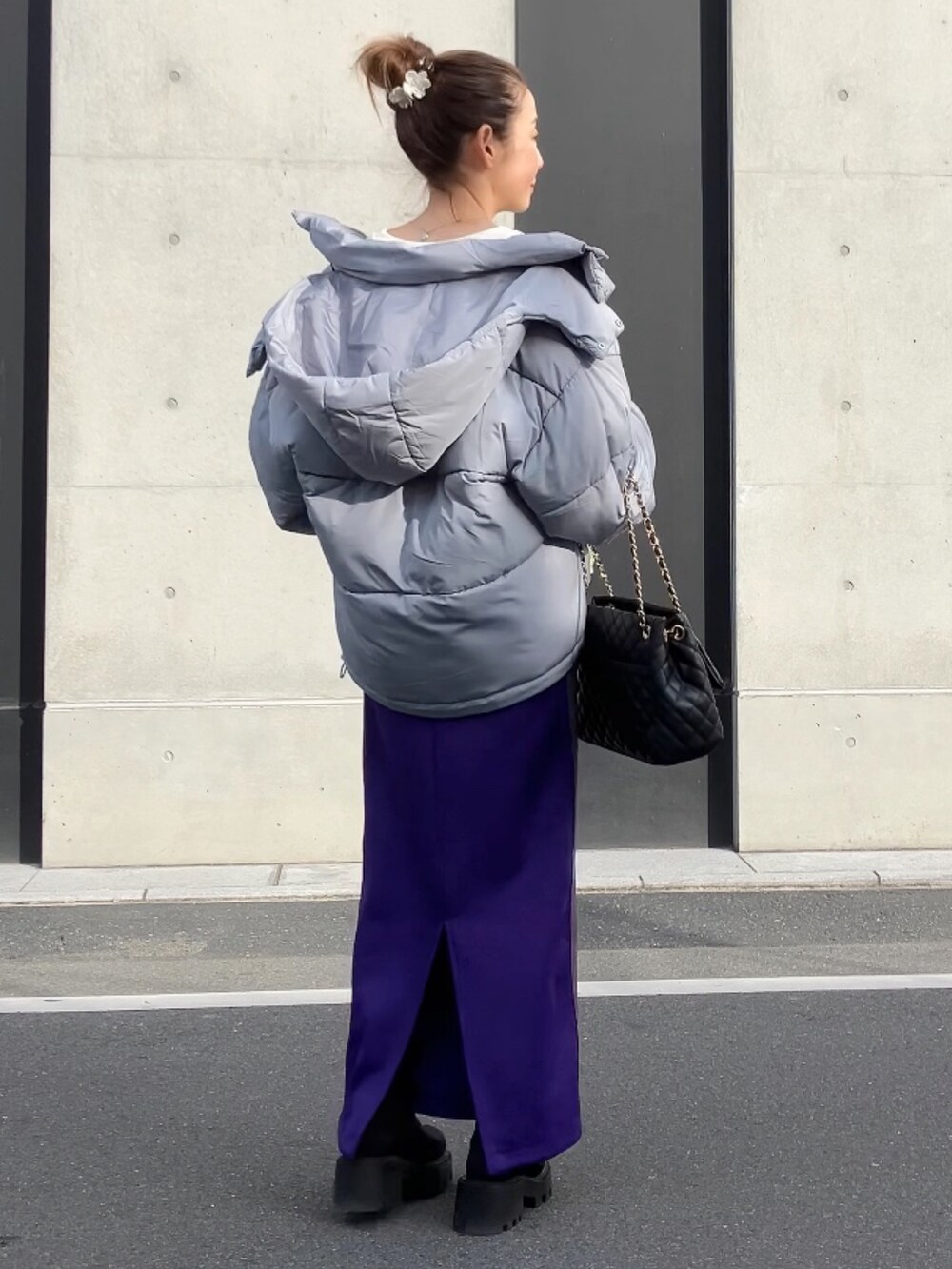 パープル系のスカート、ホワイト系のスウェット、グレー系のダウンジャケット/コートを着用したレディースの冬コーディネートの3枚目の写真