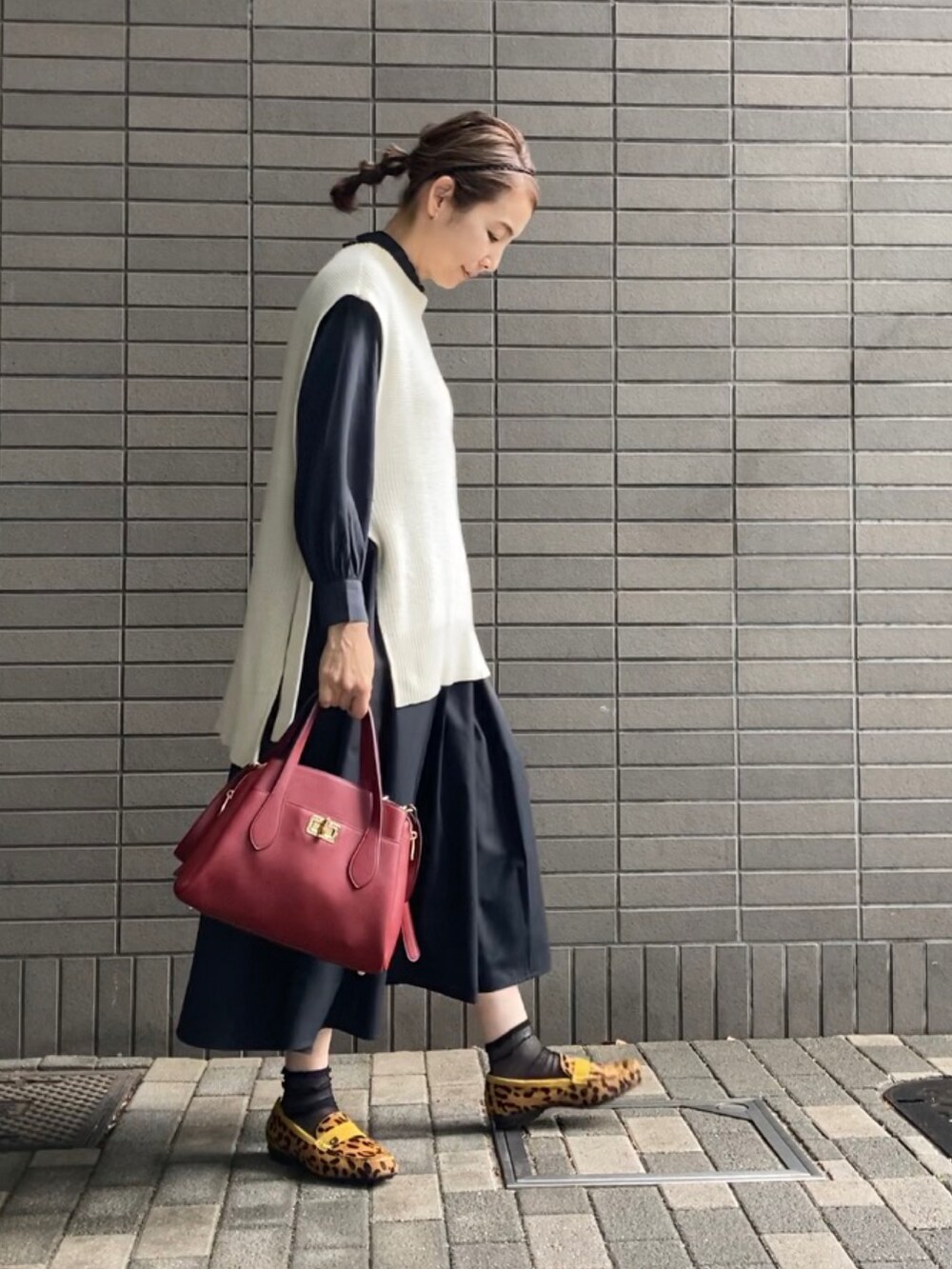 ホワイト系のベスト、ブラック系のシャツ/ブラウス、ブラック系のスカートを着用したレディースの春コーディネートの2枚目の写真